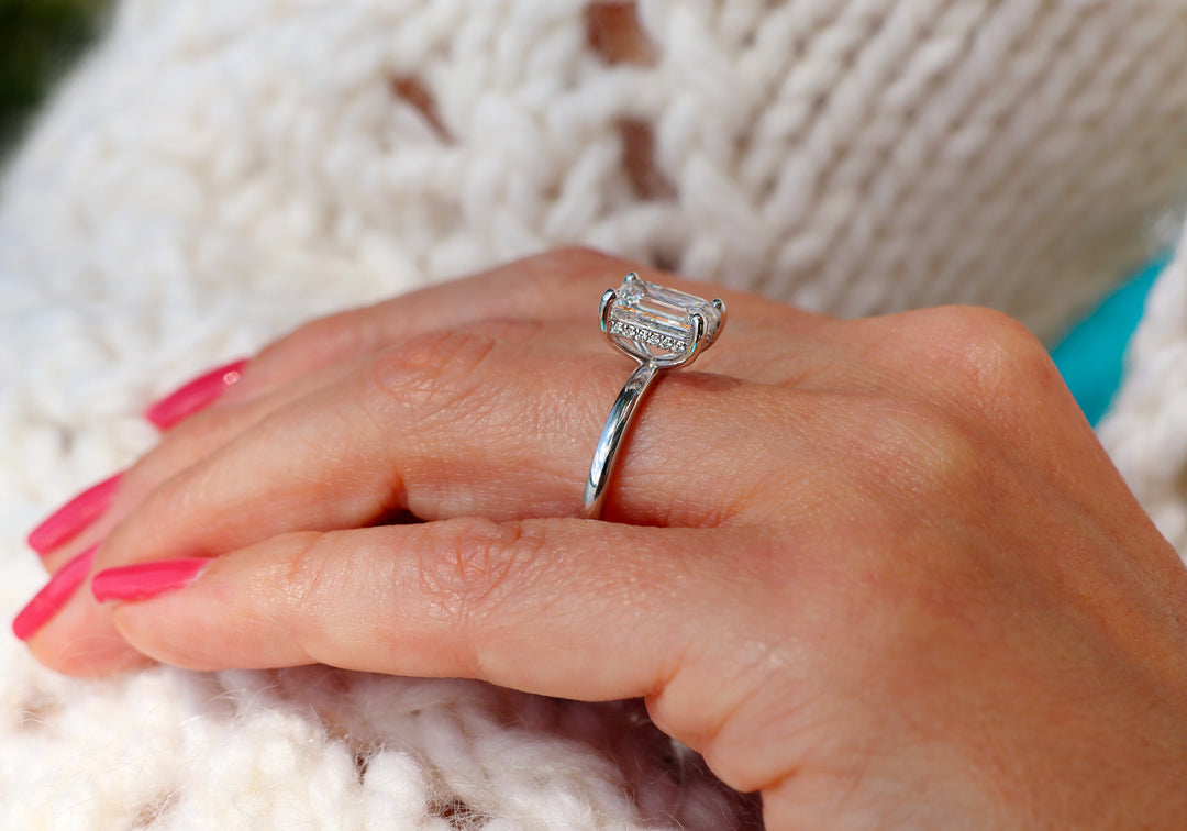 Bague solitaire L'exquise coupe émeraude en or blanc sur main – Flamme en Rose