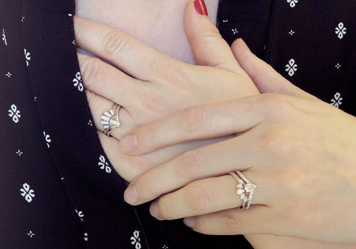 Two women's hands showing their white gold wedding rings