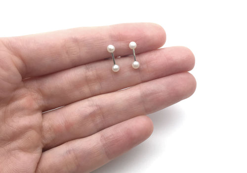boucles d'oreilles petite tige et perles blanches sur main